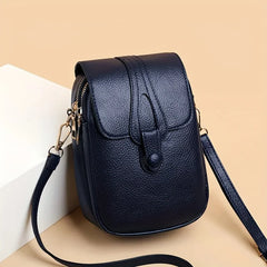 Kompakte Damen-Umhängetasche aus Leder mit minimalistischem Design und verstellbarem Riemen. in Blau